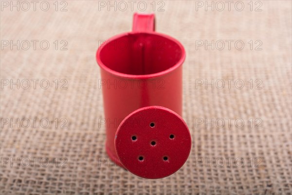 Watering can on a canvas background