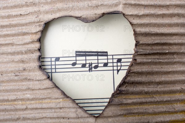 Musical notes and heart shaped burnt out of a brown cardboard