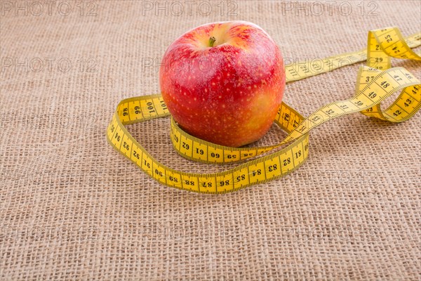 Health and diet concept with apple with a measurement tape