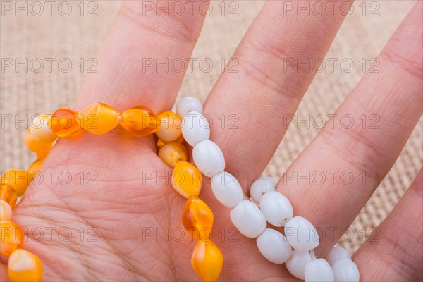 Set of praying beads of various colors in hand on canvas