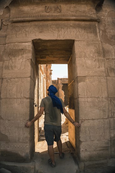 Portrait of a young man with a blue turban at the entrance to the Edfu Temple near the city of Aswan. Egypt