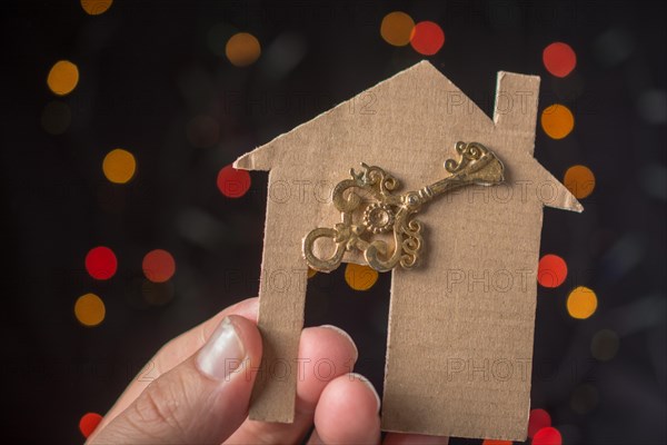 Key on paper house on a bokeh light background