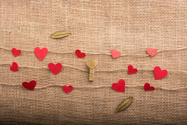 Love concept with heart shaped papers on linen threads