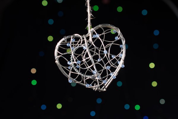 Heart shaped metal cage on a bokeh light background