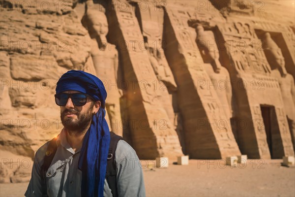 A young man wearing a blue turban visiting the Egyptian Temple of Nefertari near Abu Simbel in southern Egypt in Nubia next to Lake Nasser. Temple of Pharaoh Ramses II