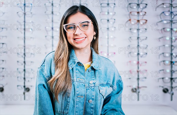 Smiling happy girl in eyeglasses with store eyeglasses background