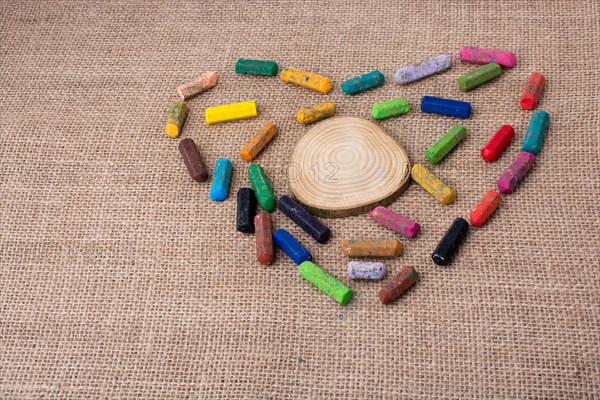 Wood piece in the middle of crayons form a heart shape