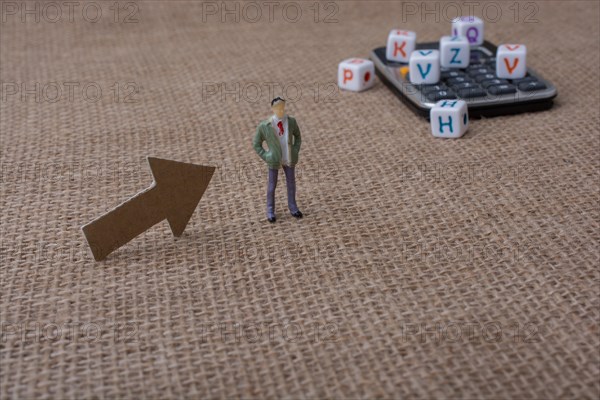 Colorful letter cubes and a calculator beside a figurine