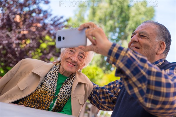 Two very happy elderly people in the garden of a nursing home