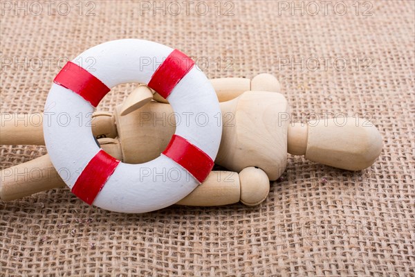 Wooden dolls posing with a life saver on canvas