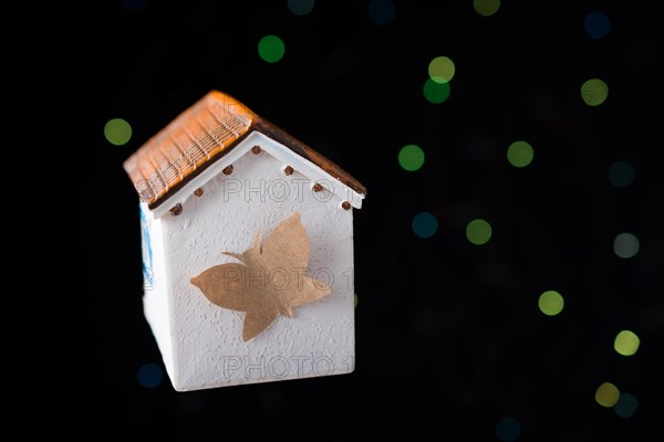 Paper butterfly on a Model house on a bokeh light