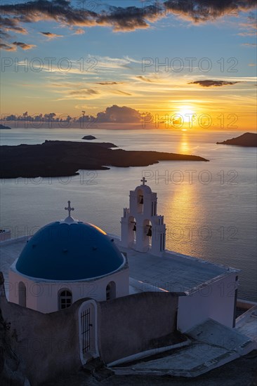 Sunset over the volcanic islands of Santorini and Anastasi Orthodox Church at sunset