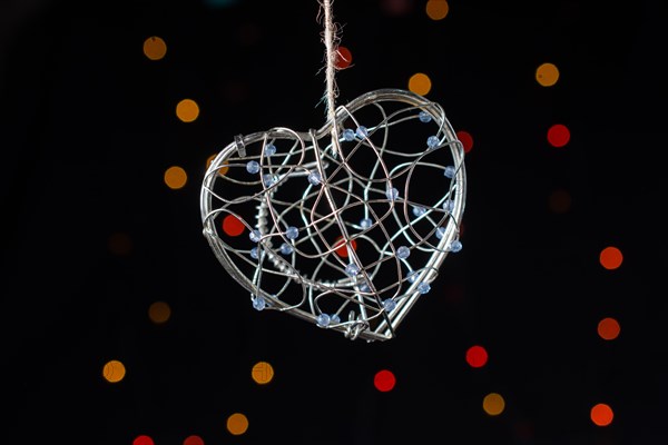 Heart shaped metal cage on a bokeh light background