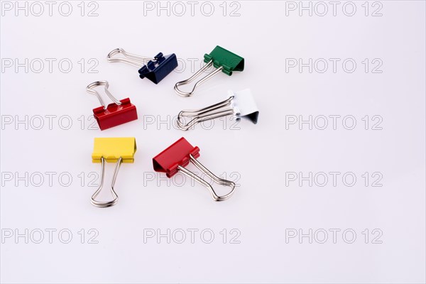 Colored paper clips on a white background