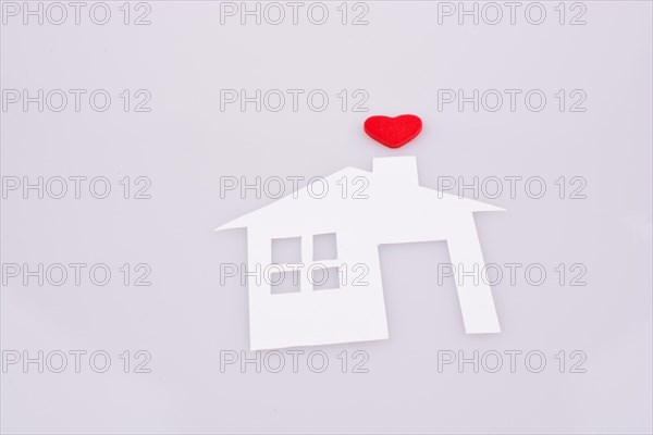 White paper house with a small red heart