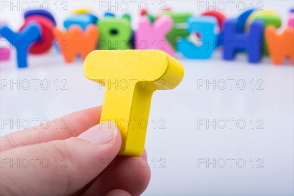 Hand holding letter cube T of made of wood