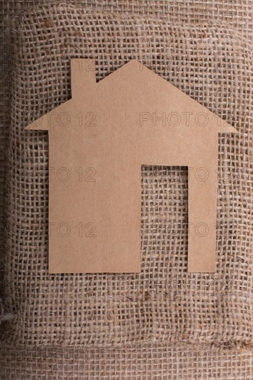 Little paper house placed on a linen canvas