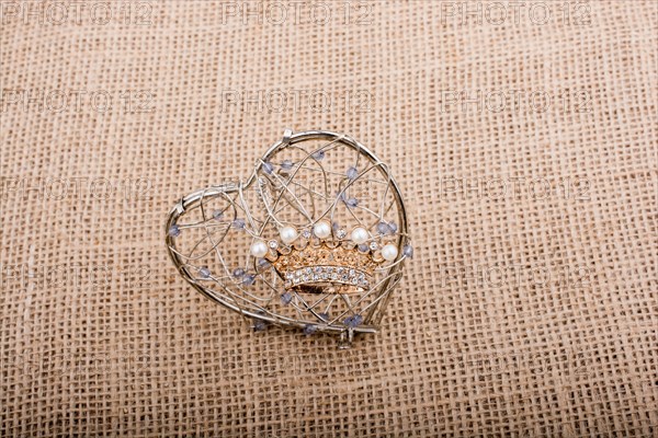 Golden color crown model with pearls on brown background