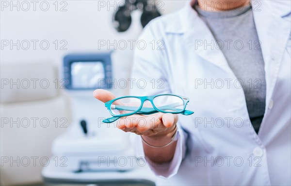 Optometrist hands showing a glasses. Oculist giving glasses in palm hand. Eyeglasses and visual health concept
