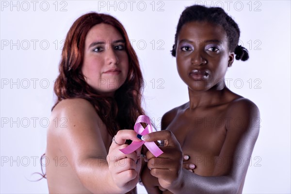 Studio portrait of two young women covering their breasts looking at camera