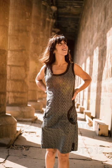 Portrait of a young brunette on the columns of the Edfu Temple near the city of Aswan. Egypt