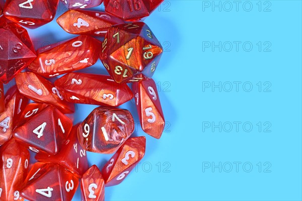Roleplay game background with different red RPG dices at side of light blue background with copy space