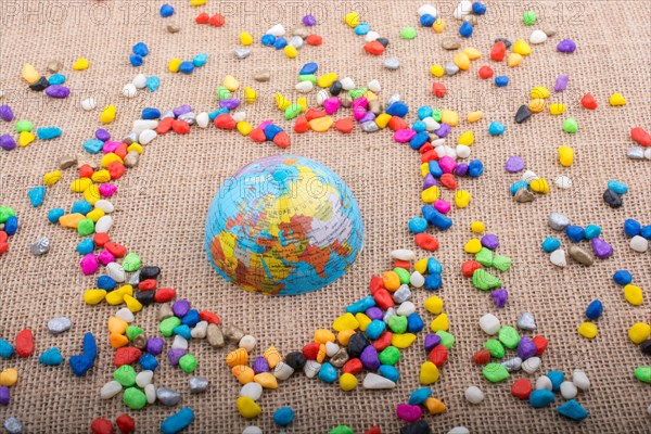 Globe in the heart form shaped by colorful pebbles