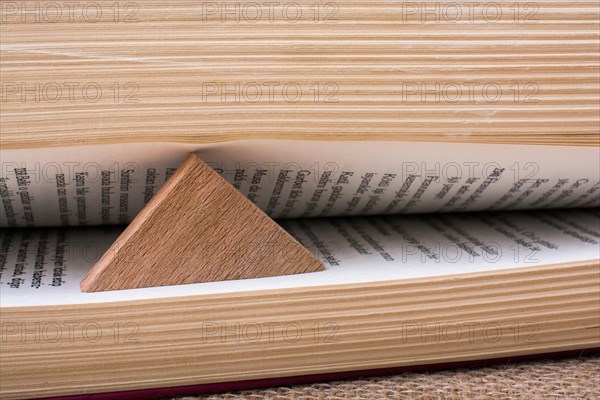 Triangle shaped wood keeping the book open