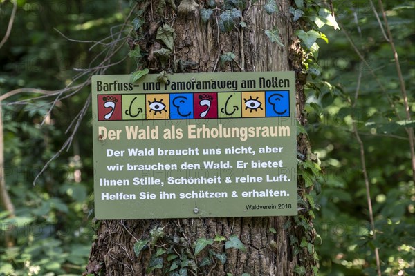 Sign The forest as a recreational space on a tree stump on the Wuppenau barefoot path on the Nollen