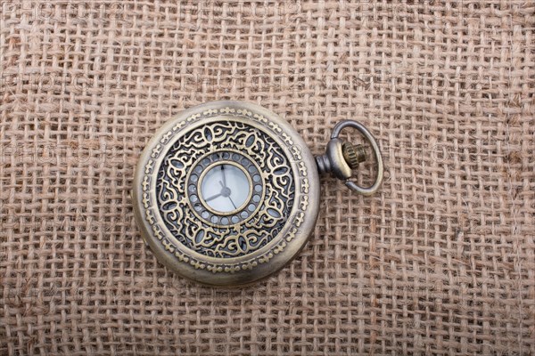 Mechanical retro styled pocket watch on linen canvas