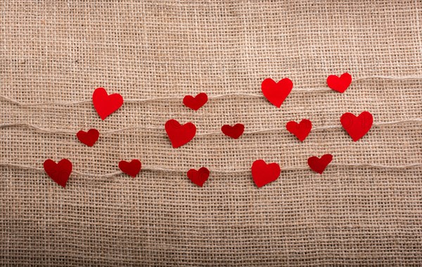 Love concept with heart shaped papers on linen threads