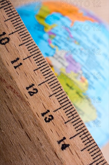 Model globe placed beside a wooden ruler