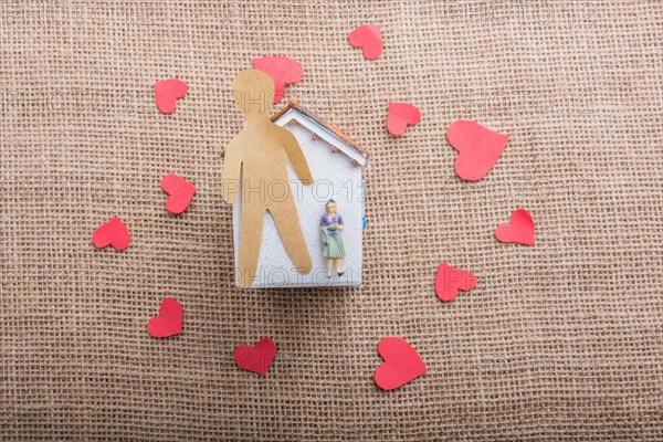 Heart shaped icons and paper house on canvas