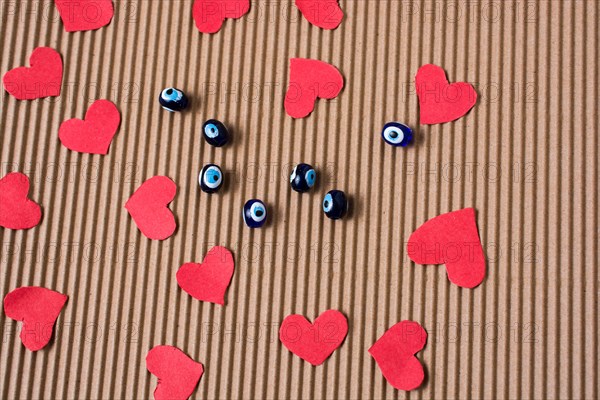 Love concept with red paper hearts and evil eye beads beads