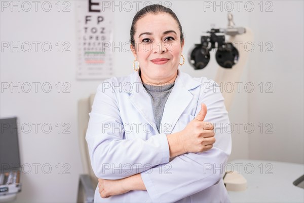 Optometry specialist with thumb up. Smiling eye doctor with thumb up in office