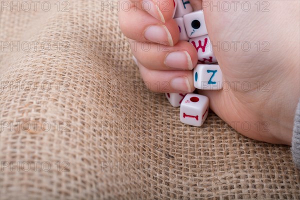 Colorful alphabet letter cubes in handon a canvas background