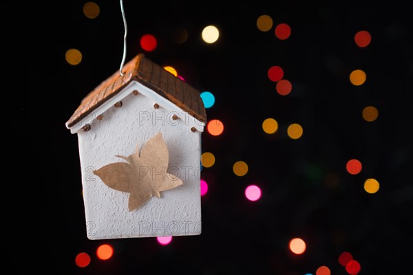 Paper butterfly on a Model house on a bokeh light