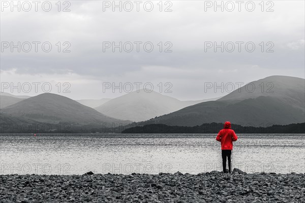 View of Mointains na Boy in a red jacket at Loch Lamond in black and white