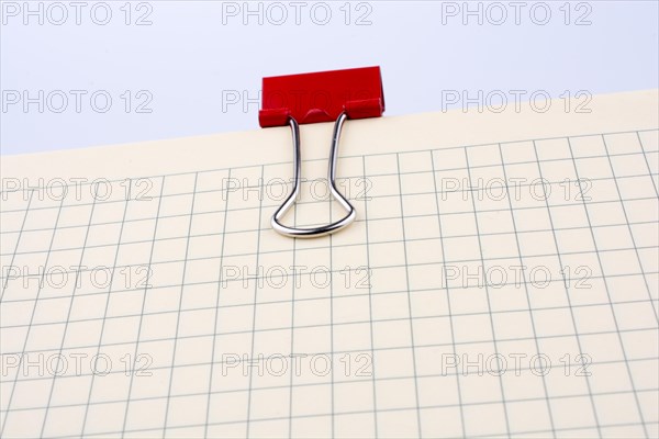 Colored paper clip on a checked notebook page