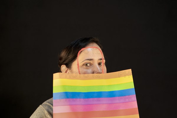 Woman holding lgbt bag. Joy of consumption. Purchases