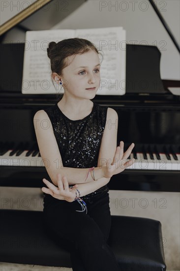 Girl sitting at the concert grand piano