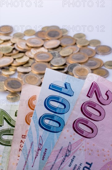 Turkish Lira coins and banknotes side by side on white background