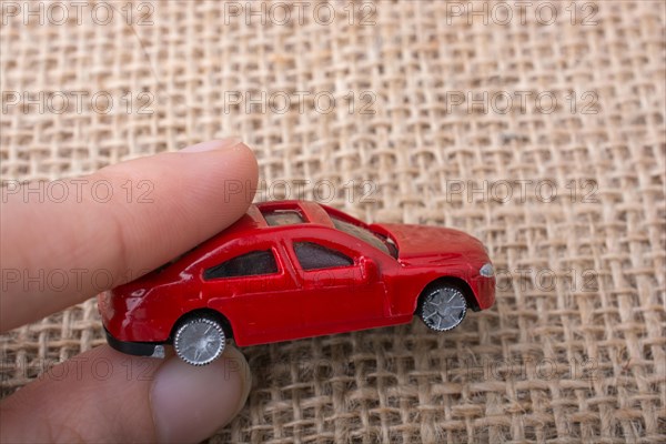 Colorful little toy car in hand on white background