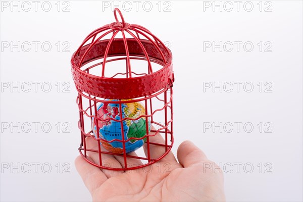 Small globe trapped in a red birdcage