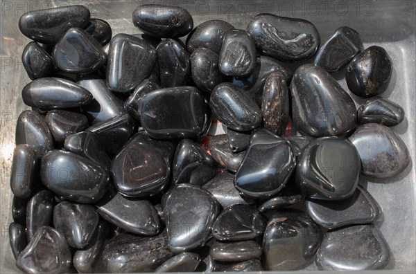 Shiny metallic gray tumbled hematite gemstone as mineral rock