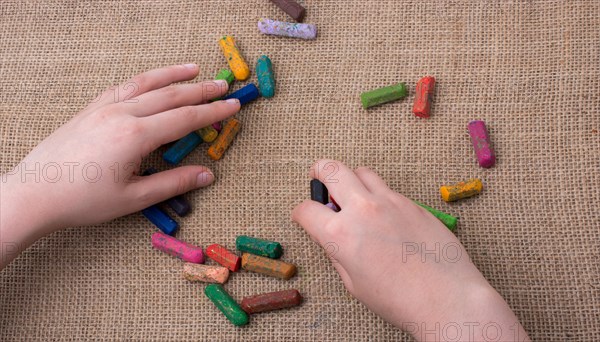 Used color crayons and a hand giving out some