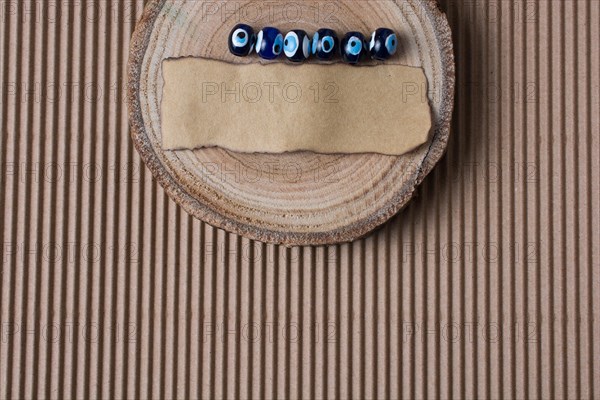 Evil eye beads and piece of burnt paper on wood log
