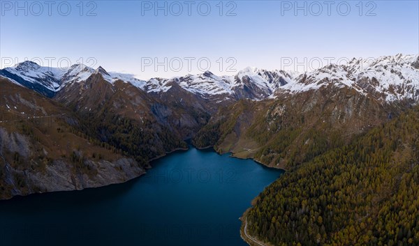 Aerial view over Lago di Luzzone with the snow-covered mountain peaks in the background