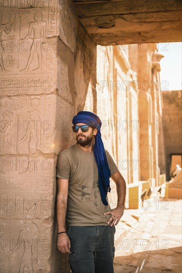 Portrait of a young man with a blue turban at the entrance to the Edfu Temple near the city of Aswan. Egypt