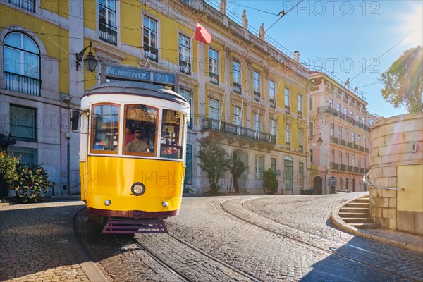 Famous vintage yellow tram 28 in the narrow streets of Alfama district in Lisbon